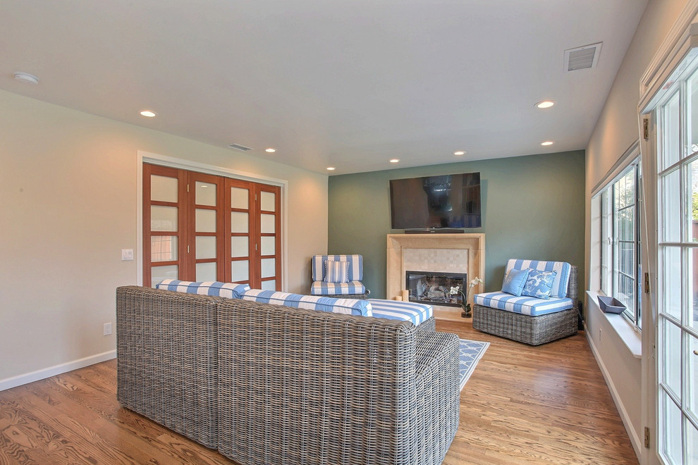 This is an example of a large contemporary open concept family room in San Francisco with green walls, bamboo floors, a standard fireplace, a tile fireplace surround, a wall-mounted tv and a game room.