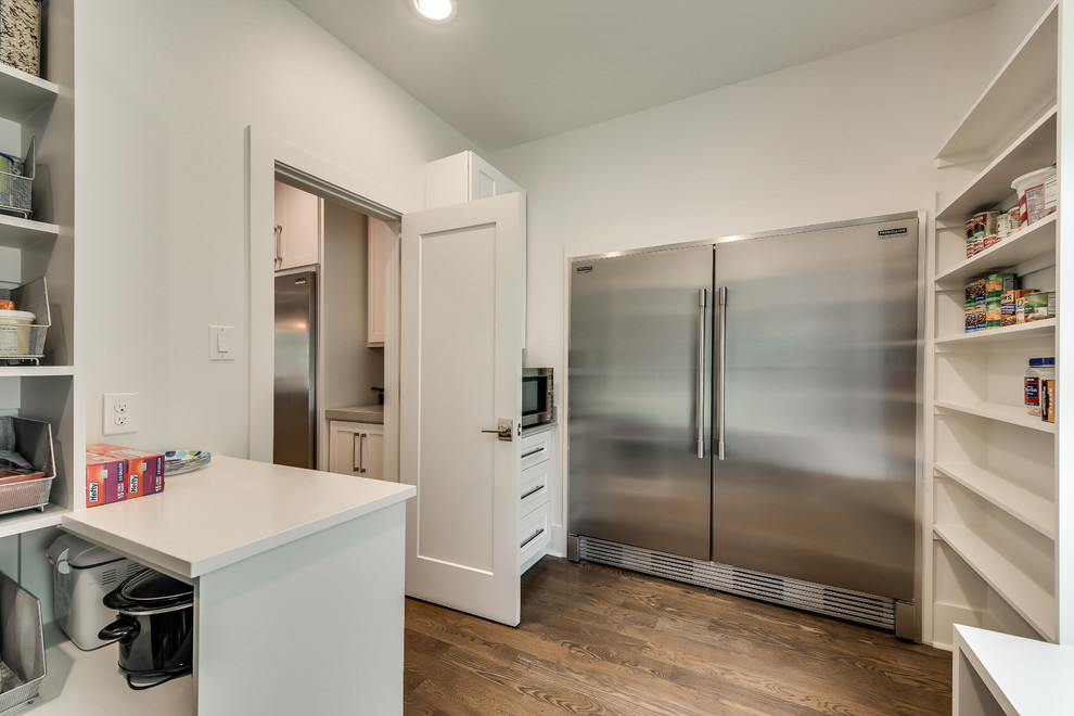 Example of a huge transitional l-shaped medium tone wood floor and brown floor open concept kitchen design in Dallas with a farmhouse sink, shaker cabinets, white cabinets, quartz countertops, gray backsplash, subway tile backsplash, stainless steel appliances, an island and multicolored countertops
