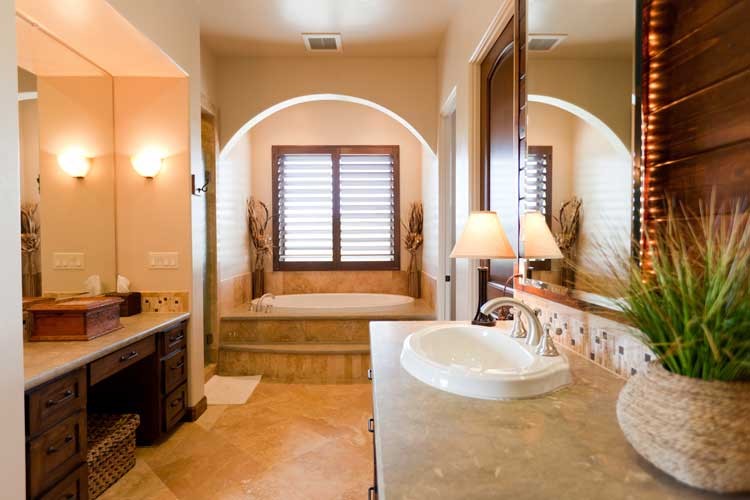 Design ideas for a mid-sized mediterranean master bathroom in San Luis Obispo with a drop-in sink, recessed-panel cabinets, dark wood cabinets, granite benchtops, an alcove tub, beige tile, ceramic tile, beige walls and travertine floors.