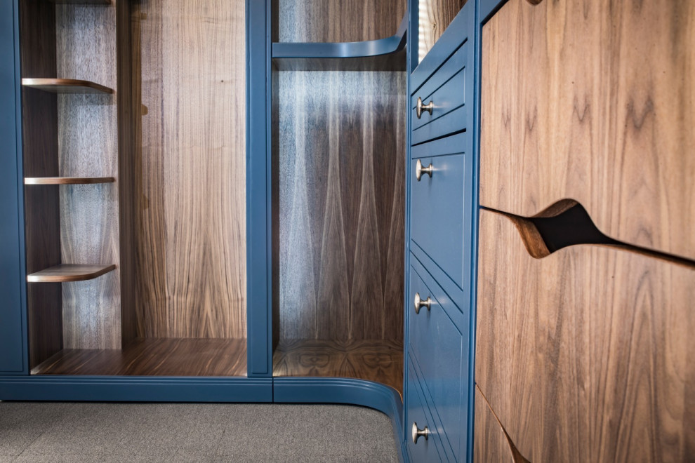 ロンドンにある高級な中くらいなコンテンポラリースタイルのおしゃれなウォークインクローゼット (シェーカースタイル扉のキャビネット、濃色木目調キャビネット) の写真