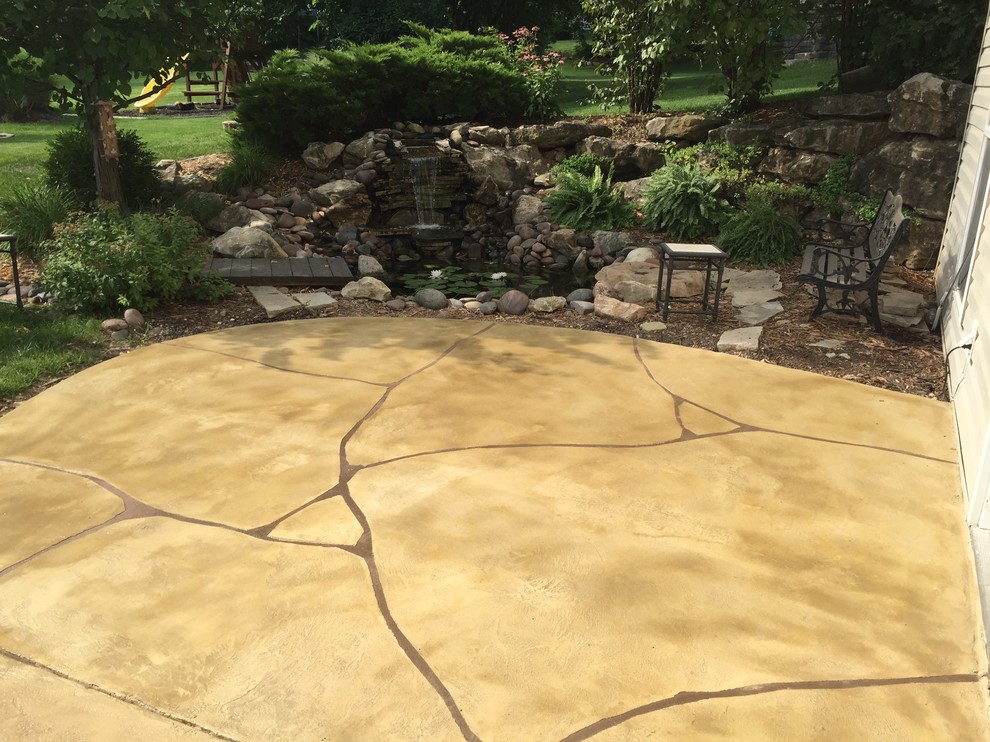 Inspiration for a mid-sized mediterranean backyard patio in St Louis with stamped concrete, a water feature and no cover.
