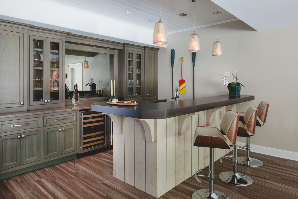 Inspiration for a beach style seated home bar in Atlanta with porcelain floors, wood benchtops, medium wood cabinets and glass-front cabinets.