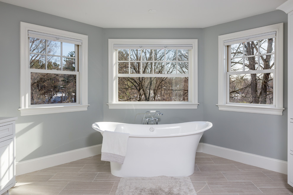 Inspiration for a large transitional master bathroom in Boston with beaded inset cabinets, white cabinets, a freestanding tub, a double shower, a two-piece toilet, gray tile, ceramic tile, grey walls, ceramic floors, an undermount sink and engineered quartz benchtops.