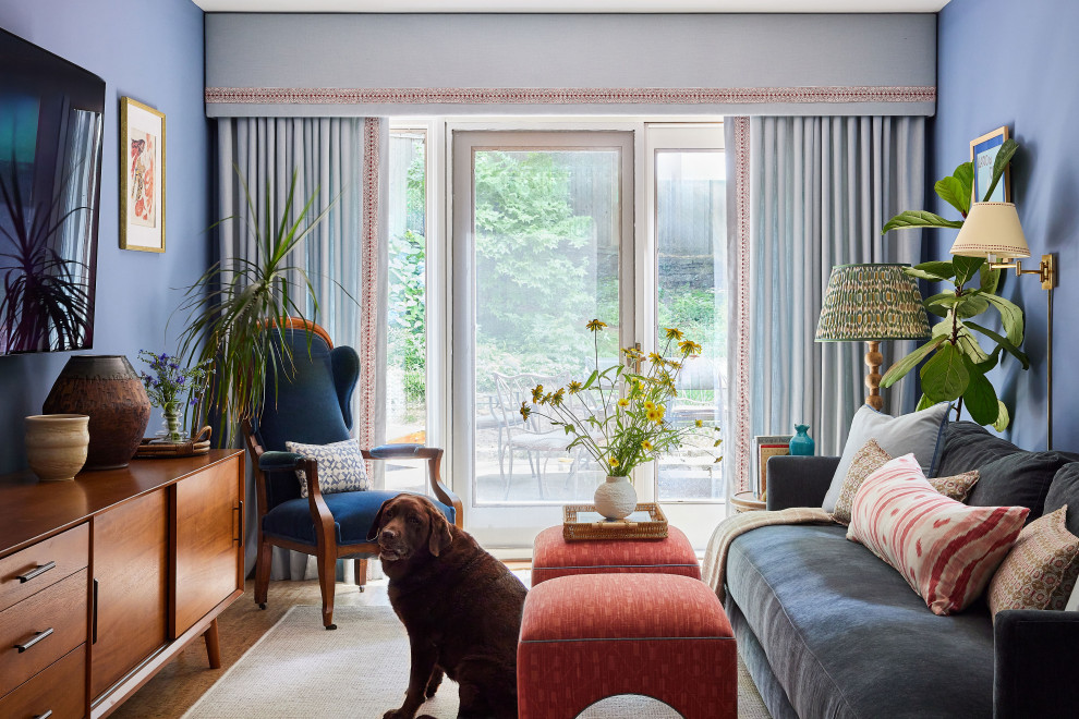 Transitional medium tone wood floor and brown floor living room photo in New York with blue walls and a wall-mounted tv
