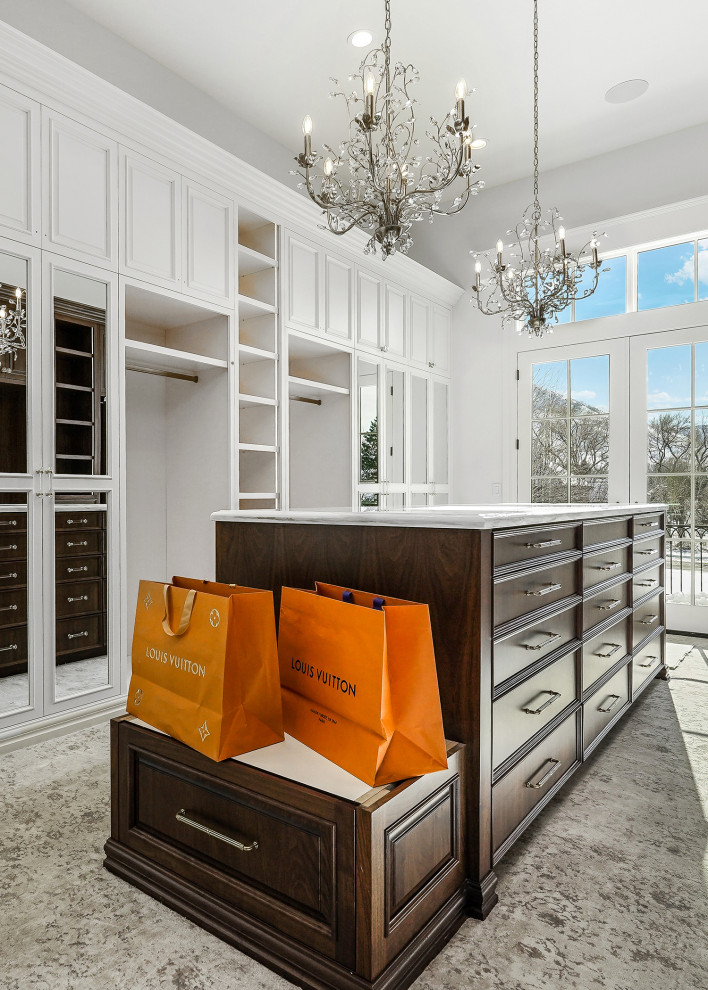This is an example of an expansive gender-neutral walk-in wardrobe in Salt Lake City with recessed-panel cabinets, dark wood cabinets, medium hardwood floors and brown floor.