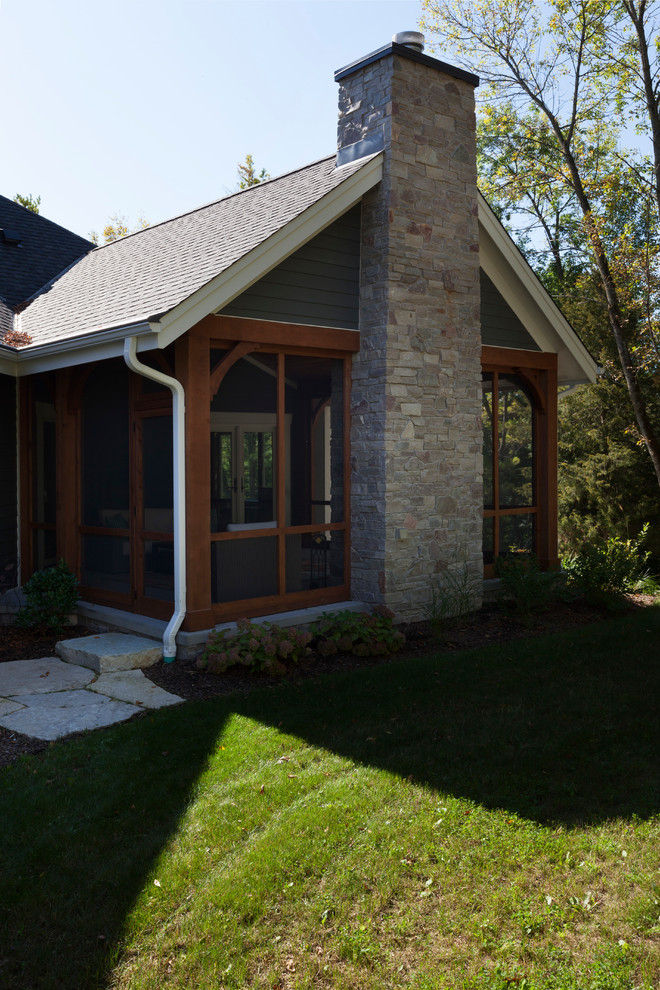 This is an example of a large arts and crafts one-storey concrete blue house exterior in Milwaukee with a gable roof and a shingle roof.