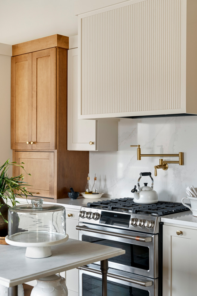 Example of a mid-sized transitional galley medium tone wood floor, brown floor and vaulted ceiling eat-in kitchen design in Minneapolis with an undermount sink, shaker cabinets, quartz countertops, white backsplash, subway tile backsplash, stainless steel appliances, an island and white countertops