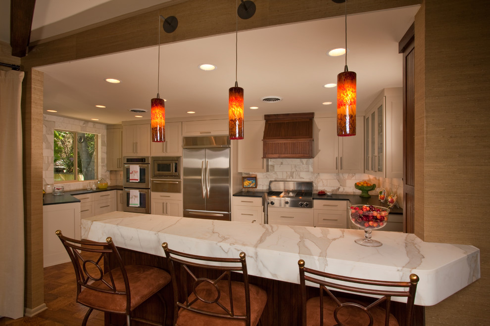 Eat-in kitchen - transitional eat-in kitchen idea in Austin with an undermount sink, white cabinets, marble countertops, white backsplash, stone tile backsplash and stainless steel appliances