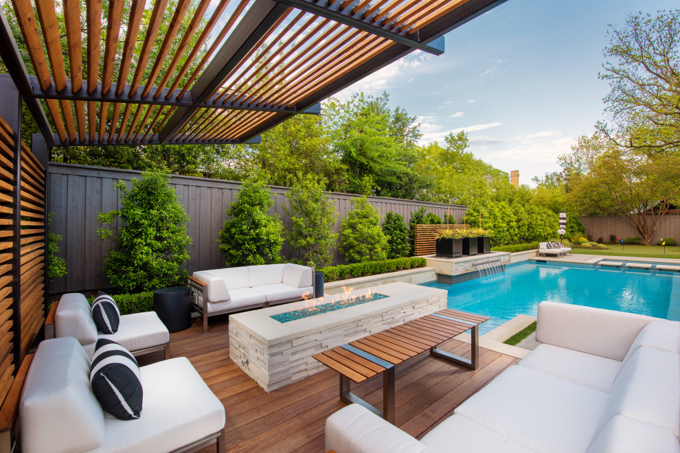 This is an example of a mid-sized contemporary backyard deck in Dallas with a fire feature and a pergola.