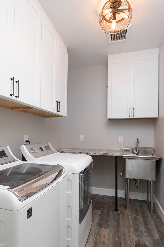 Example of a mid-sized transitional l-shaped vinyl floor and brown floor dedicated laundry room design with an utility sink, recessed-panel cabinets, white cabinets, granite countertops, beige walls, a side-by-side washer/dryer and beige countertops