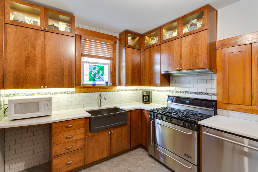 This is an example of a small traditional l-shaped kitchen in Baltimore with a farmhouse sink, flat-panel cabinets, stainless steel appliances and no island.