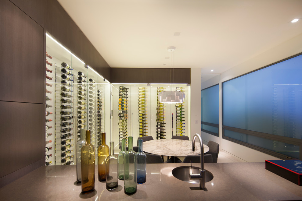 Photo of a mid-sized contemporary wine cellar in Orange County with limestone floors and storage racks.