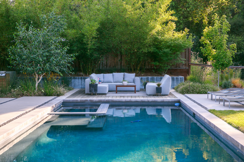 This is an example of a large contemporary backyard rectangular pool in San Francisco with a hot tub.