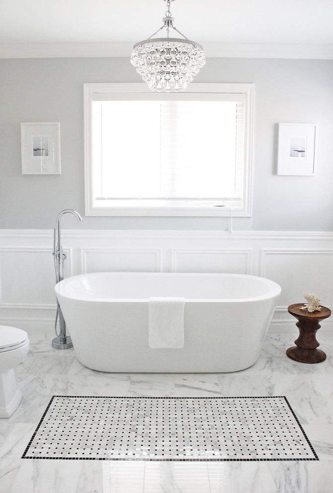 Photo of a contemporary bathroom in Toronto with a freestanding tub and white tile.
