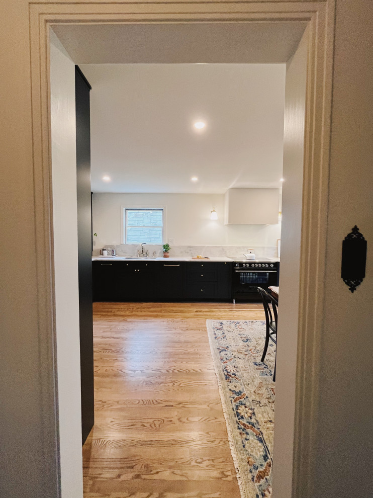 Inspiration for a large transitional l-shaped medium tone wood floor and brown floor eat-in kitchen remodel with an undermount sink, shaker cabinets, blue cabinets, quartzite countertops, stone slab backsplash, paneled appliances, no island and gray countertops