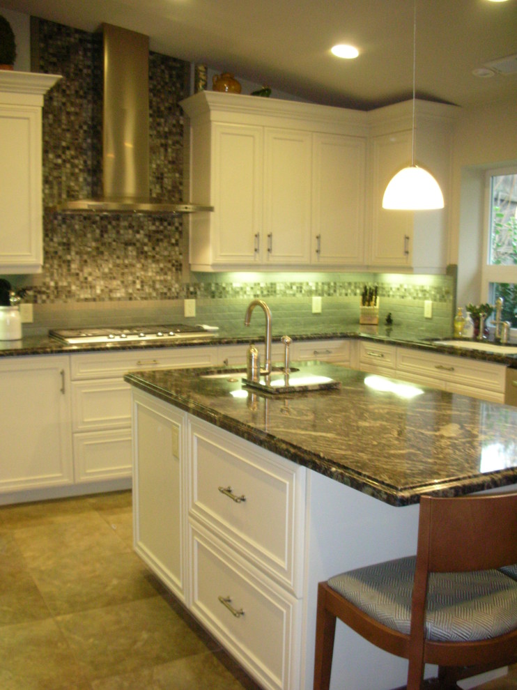 Mid-sized transitional u-shaped open plan kitchen in Sacramento with an undermount sink, recessed-panel cabinets, white cabinets, granite benchtops, green splashback, glass tile splashback, stainless steel appliances, porcelain floors and with island.