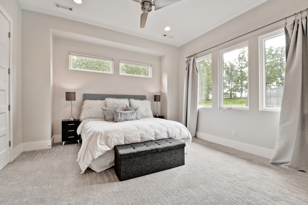 This is an example of a large guest bedroom in Other with carpet and grey floor.