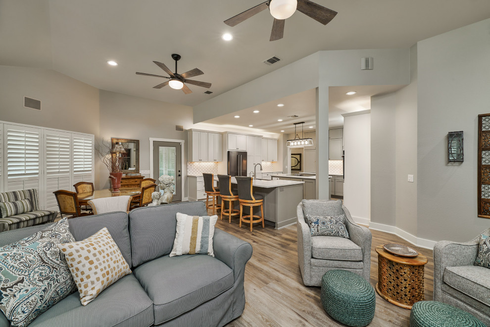 Mid-sized transitional u-shaped vinyl floor and brown floor kitchen pantry photo in Austin with a farmhouse sink, shaker cabinets, white cabinets, quartz countertops, white backsplash, marble backsplash, black appliances, two islands and white countertops