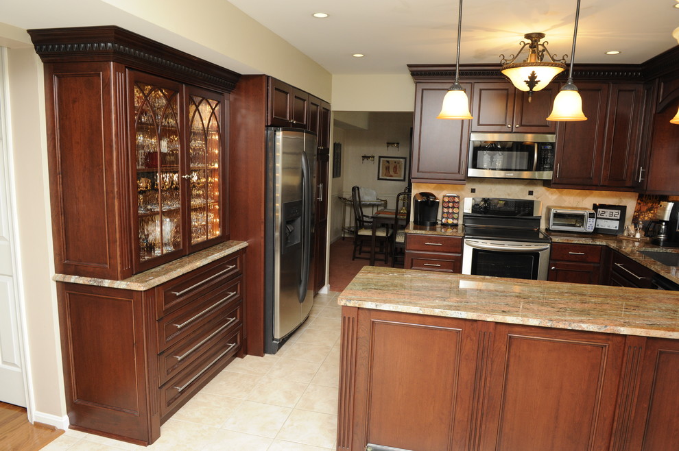 Inspiration for a mid-sized transitional u-shaped limestone floor enclosed kitchen remodel in Baltimore with an undermount sink, beaded inset cabinets, dark wood cabinets, granite countertops, beige backsplash, stone tile backsplash, stainless steel appliances and a peninsula