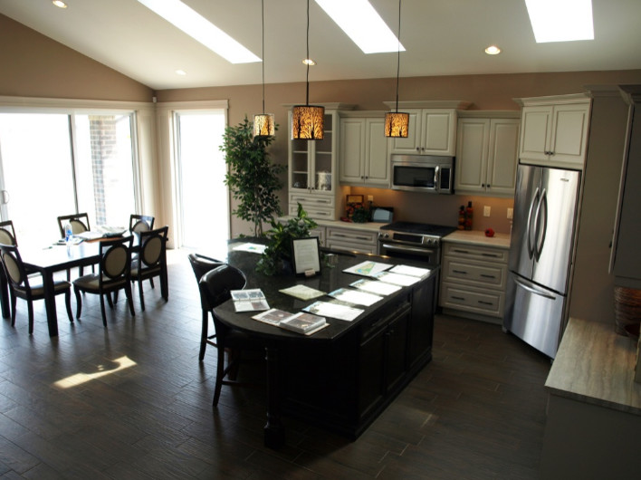 Example of a mid-sized transitional l-shaped porcelain tile and brown floor eat-in kitchen design with raised-panel cabinets, beige cabinets, granite countertops and an island