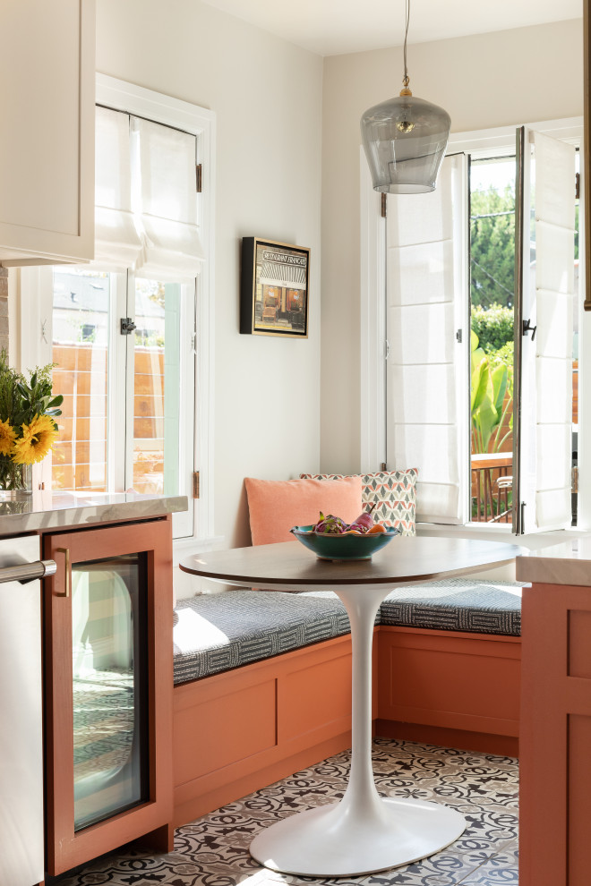 This is an example of a mediterranean kitchen in Other with orange cabinets, cement tiles and no island.