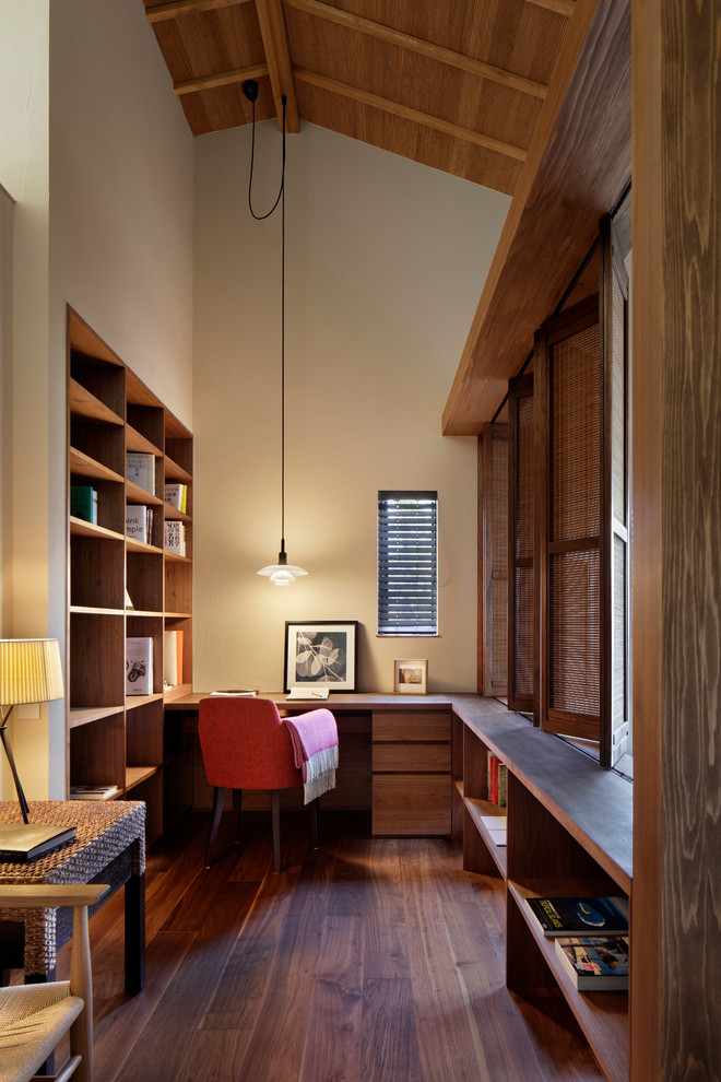 This is an example of a midcentury study room in Fukuoka with white walls, dark hardwood floors and a built-in desk.