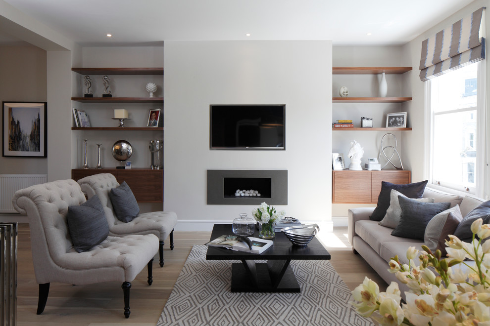 Design ideas for a contemporary formal living room in Hampshire with white walls, light hardwood floors, a ribbon fireplace, a metal fireplace surround and a wall-mounted tv.