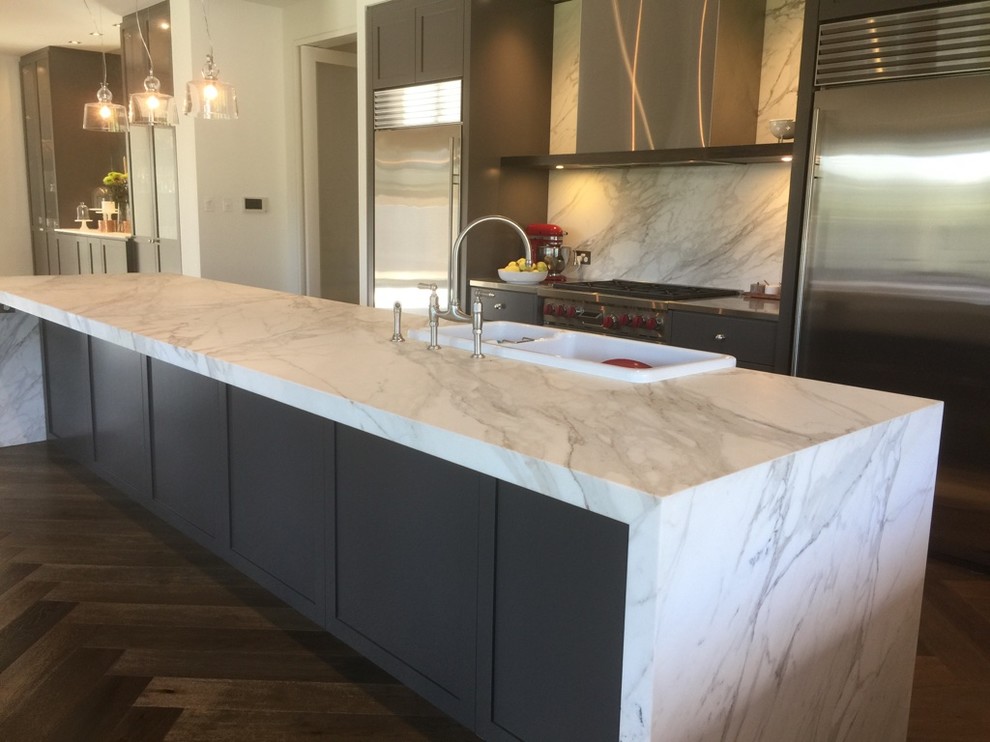 Inspiration for a mid-sized contemporary single-wall kitchen in Adelaide with a farmhouse sink, shaker cabinets, black cabinets, marble benchtops, marble splashback, stainless steel appliances, dark hardwood floors, with island and brown floor.