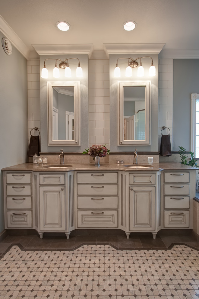 Inspiration for a large traditional master bathroom in Other with an undermount sink, raised-panel cabinets, distressed cabinets, limestone benchtops, a drop-in tub, a double shower, a two-piece toilet, beige tile, stone tile, blue walls and mosaic tile floors.