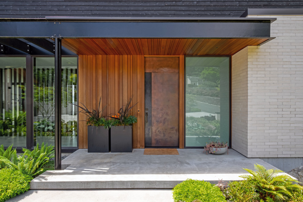Inspiration for a mid-sized modern three-storey black house exterior with wood siding, a shed roof and a metal roof.