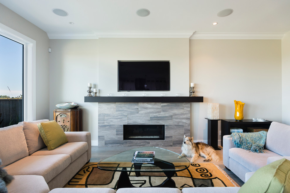 Mid-sized transitional open concept family room in Vancouver with grey walls, porcelain floors, a standard fireplace, a tile fireplace surround and a wall-mounted tv.