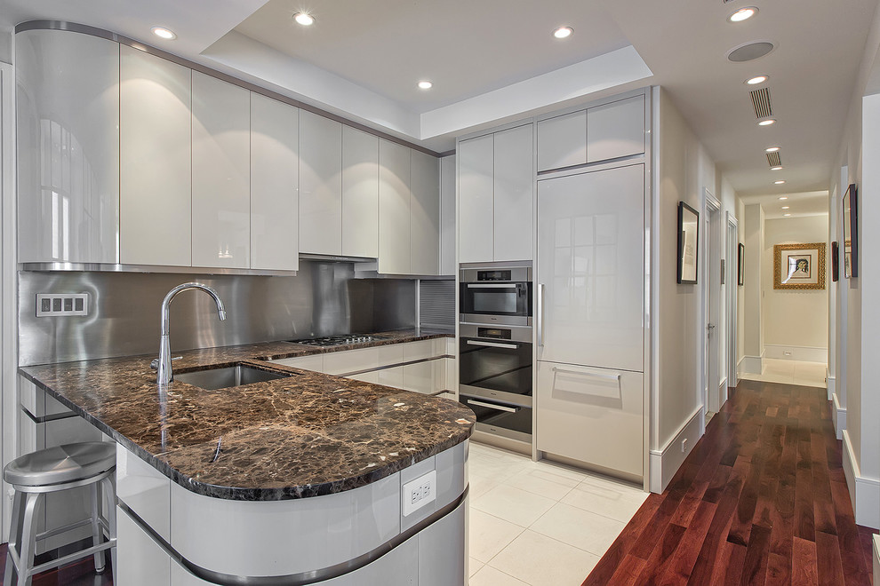 This is an example of a small contemporary u-shaped open plan kitchen in New York with an undermount sink, flat-panel cabinets, grey cabinets, metallic splashback, panelled appliances and no island.
