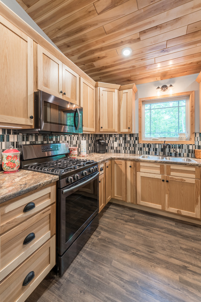 Mid-sized country l-shaped eat-in kitchen in Minneapolis with an undermount sink, shaker cabinets, light wood cabinets, laminate benchtops, multi-coloured splashback, mosaic tile splashback, stainless steel appliances, vinyl floors, with island, brown floor and multi-coloured benchtop.