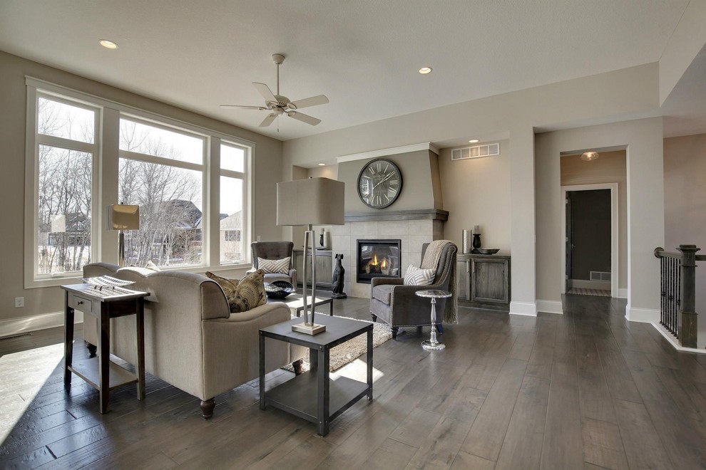 Design ideas for a mid-sized transitional open concept family room in Minneapolis with grey walls, dark hardwood floors, no tv, a standard fireplace and a tile fireplace surround.