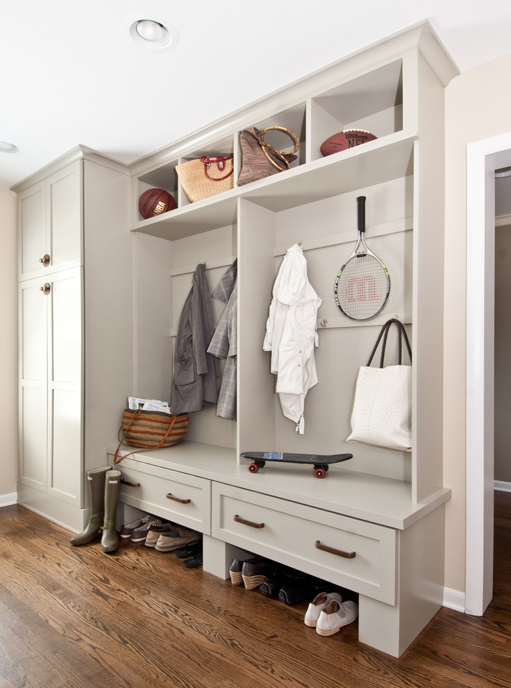 This is an example of a transitional mudroom in Chicago with beige walls and dark hardwood floors.