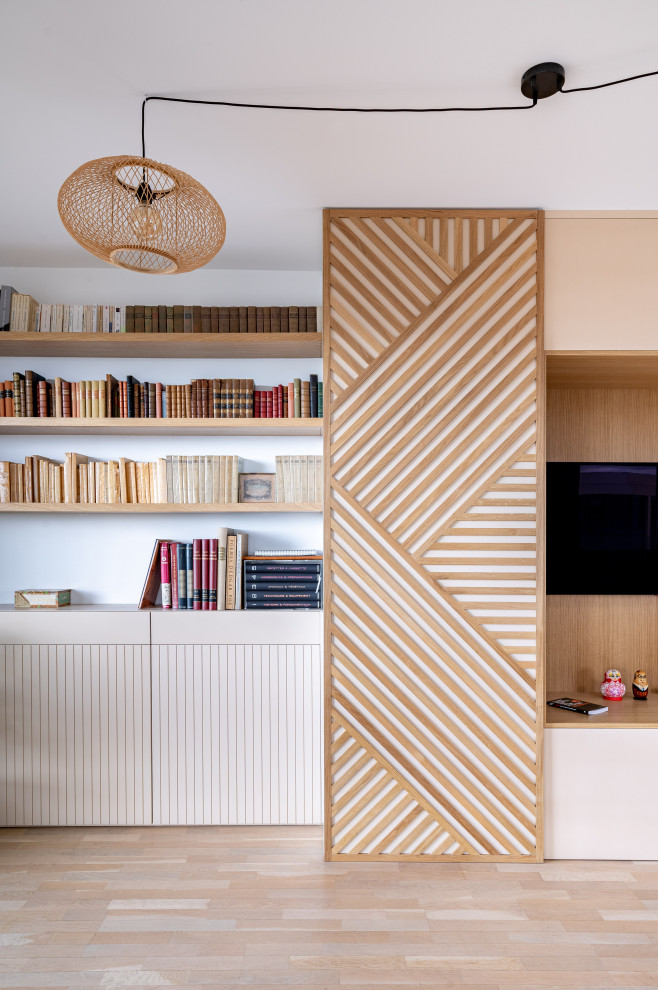 Foto di un grande soggiorno nordico aperto con libreria, pareti beige, parquet chiaro, TV a parete e pareti in legno