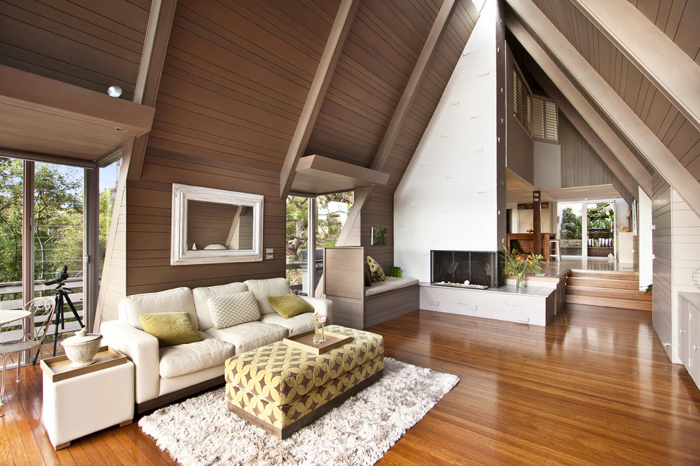Photo of a contemporary formal living room in Paris with medium hardwood floors and a two-sided fireplace.