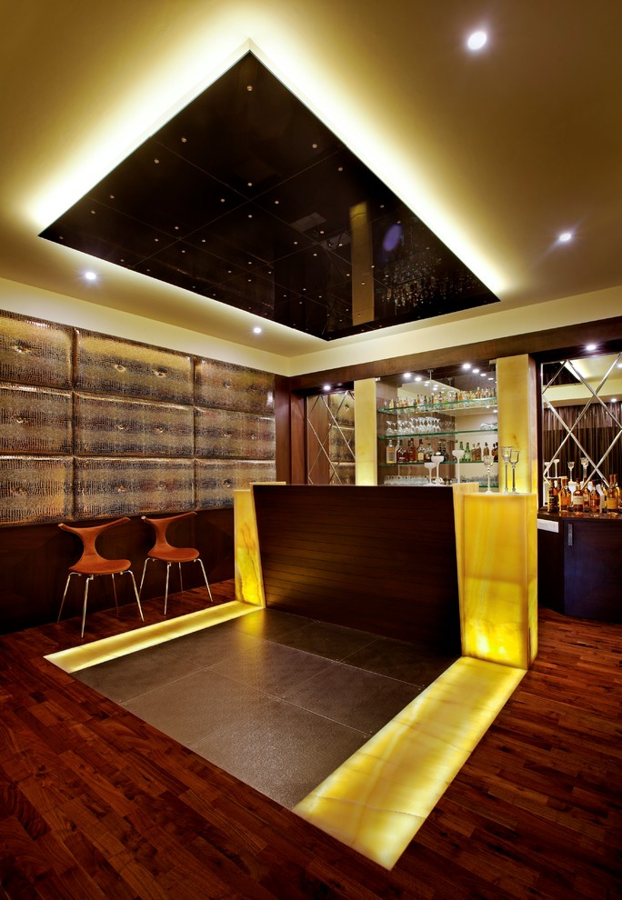 Photo of a mid-sized contemporary single-wall home bar in Bengaluru with open cabinets, yellow cabinets, wood benchtops, yellow splashback, dark hardwood floors, multi-coloured floor and yellow benchtop.
