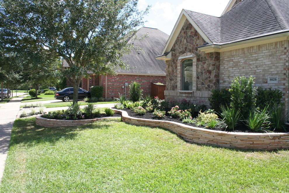 Design ideas for a large traditional front yard full sun driveway for summer in Houston with concrete pavers.