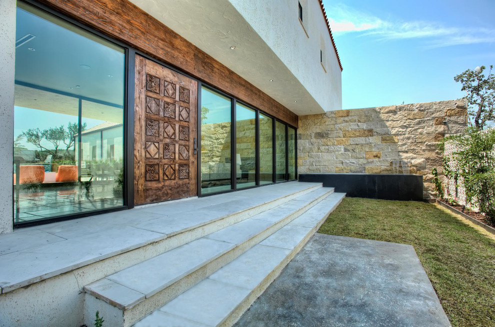 Photo of a mid-sized contemporary front door in Austin with brown walls, concrete floors, a single front door, a medium wood front door and grey floor.