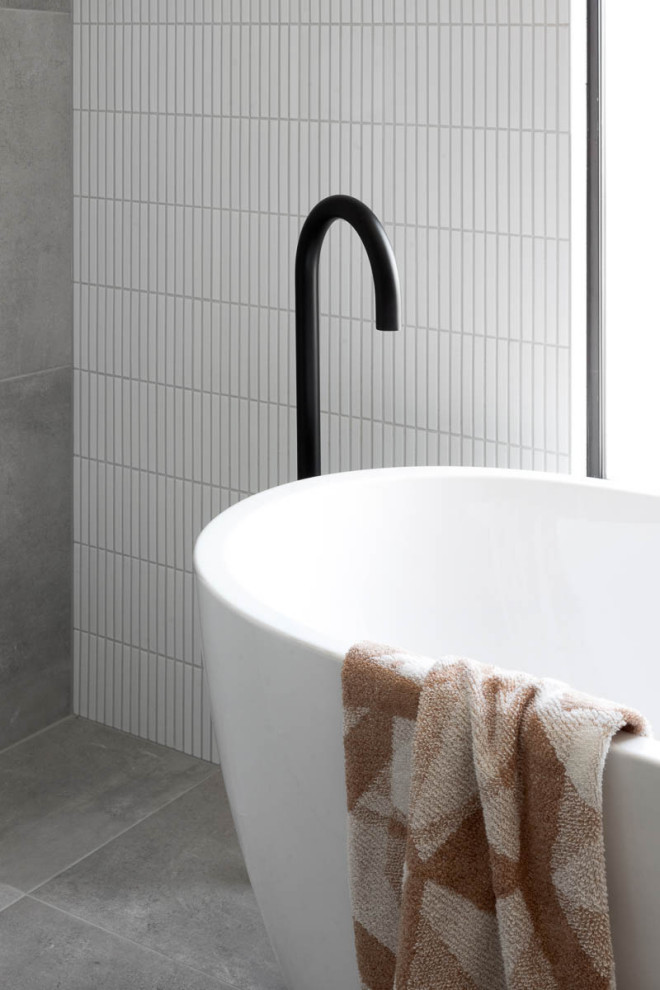 Inspiration for a mid-sized contemporary master bathroom in Melbourne with a freestanding tub, white tile, ceramic tile, white walls, grey floor, a freestanding vanity and porcelain floors.
