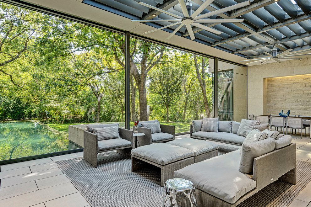 Photo of an expansive modern sunroom in Dallas with porcelain floors, a standard fireplace, a skylight and beige floor.