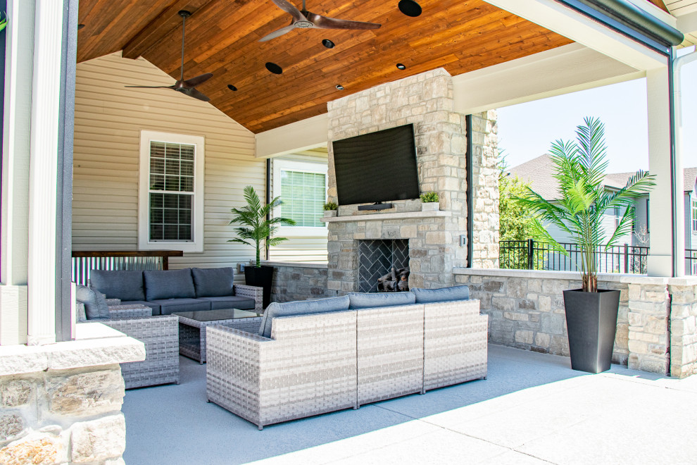 Inspiration for a medium sized back patio in St Louis with a fireplace, concrete slabs and a roof extension.