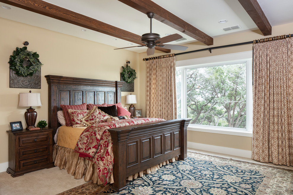 This is an example of a large country master bedroom in Austin with beige walls, carpet and beige floor.