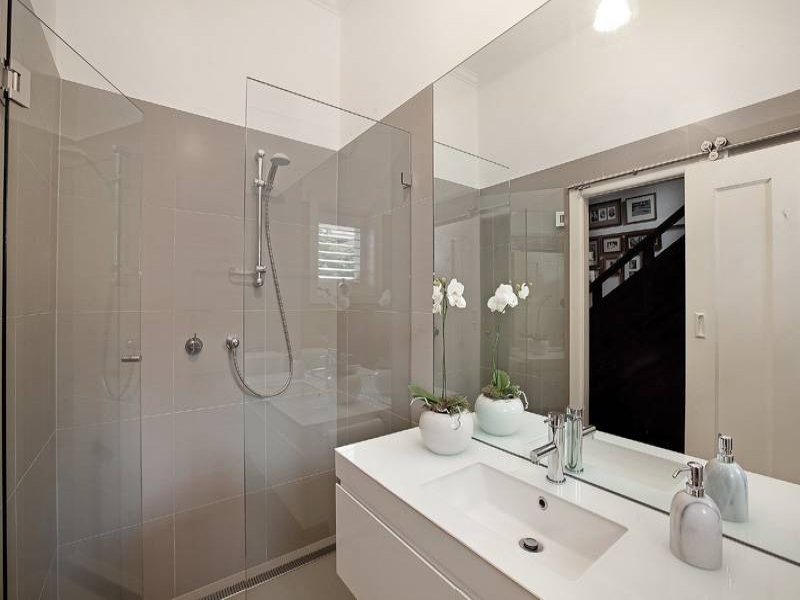 Пример оригинального дизайна: маленькая ванная комната в современном стиле с подвесной раковиной, плоскими фасадами, белыми фасадами, стеклянной столешницей, двойным душем, инсталляцией, серой плиткой, керамической плиткой, белыми стенами и полом из керамической плитки для на участке и в саду