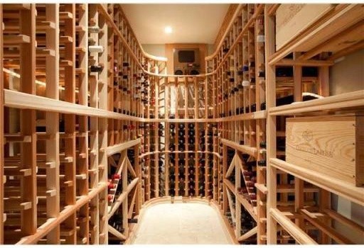 This is an example of a mid-sized traditional wine cellar in Vancouver with porcelain floors, storage racks and beige floor.