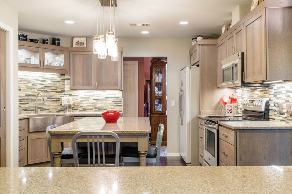 Enclosed kitchen - mid-sized transitional u-shaped medium tone wood floor enclosed kitchen idea in Miami with a farmhouse sink, shaker cabinets, gray cabinets, quartz countertops, gray backsplash, glass tile backsplash, white appliances and an island