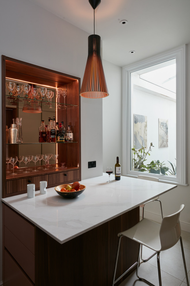 Design ideas for a small contemporary l-shaped eat-in kitchen in London with an integrated sink, louvered cabinets, red cabinets, quartzite benchtops, beige splashback, engineered quartz splashback, black appliances, ceramic floors, with island, brown floor and beige benchtop.