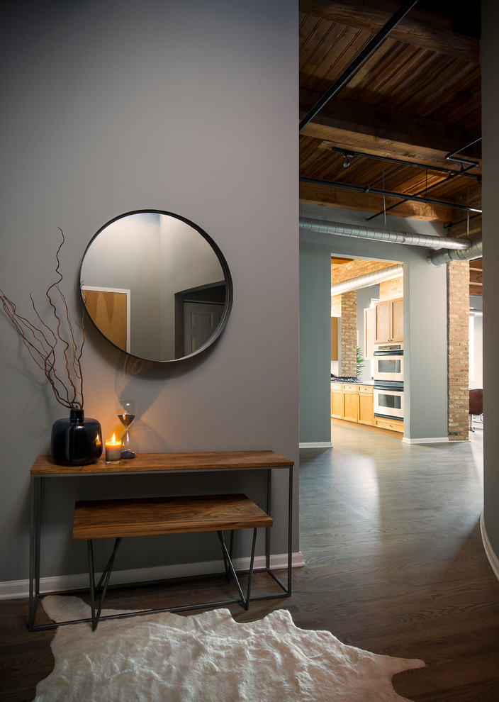 Mid-sized industrial entryway in Chicago with grey walls, a single front door and a medium wood front door.