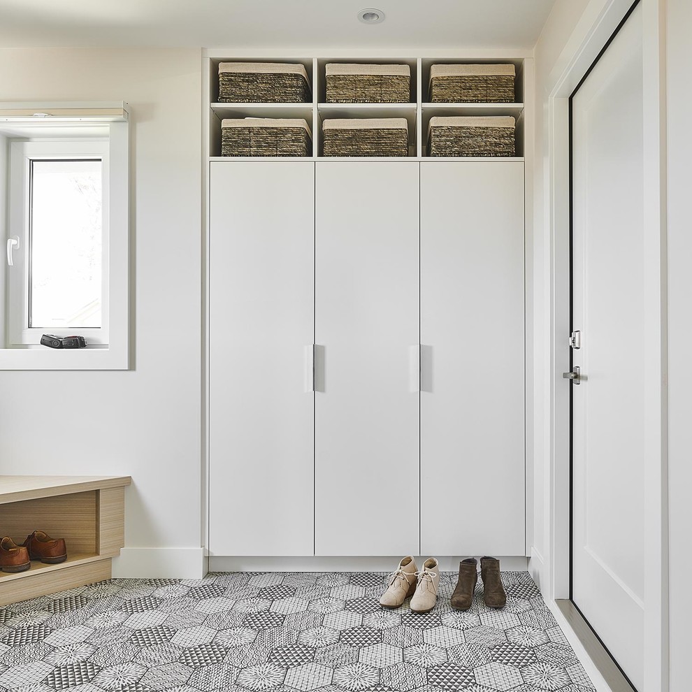 Photo of a mid-sized scandinavian mudroom in Vancouver with ceramic floors, a single front door, a white front door, multi-coloured floor and white walls.